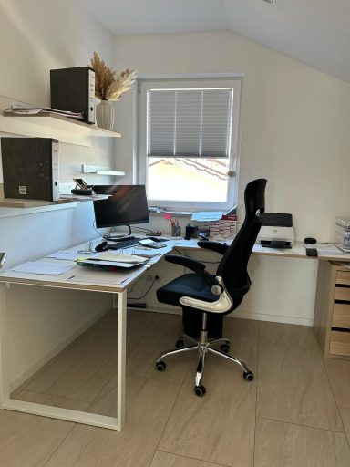 Modernes Büro mit Schreibtisch, Computer, Bürostuhl und Regalen an der Wand.